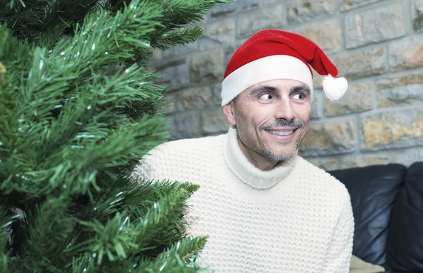Usmívající se muž líbí vánoční stromeček — Stock fotografie