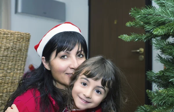 Menina do bebê com a mãe apreciando a árvore de Natal — Fotografia de Stock