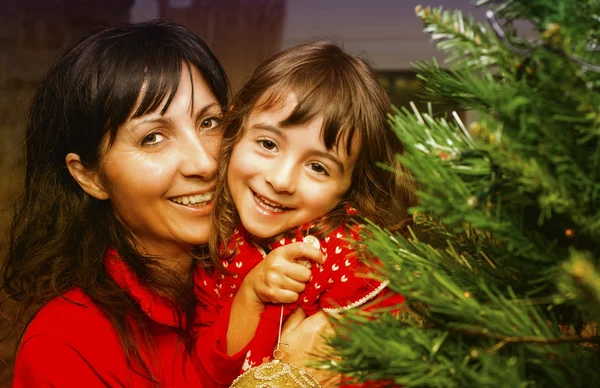 Flicka med mamma njuter julgran — Stockfoto