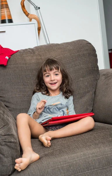 A lány mosolyogva, miközben játszik a tabletta — Stock Fotó