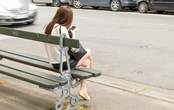 Femme avec téléphone sur banc — Photo