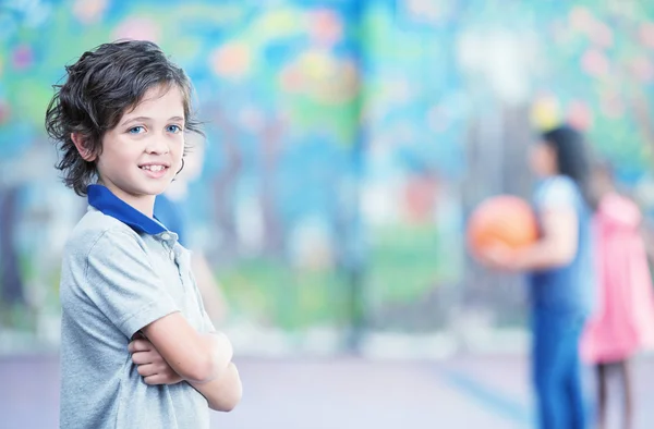 Happy kid smiling in schoolyard — Stock Photo, Image