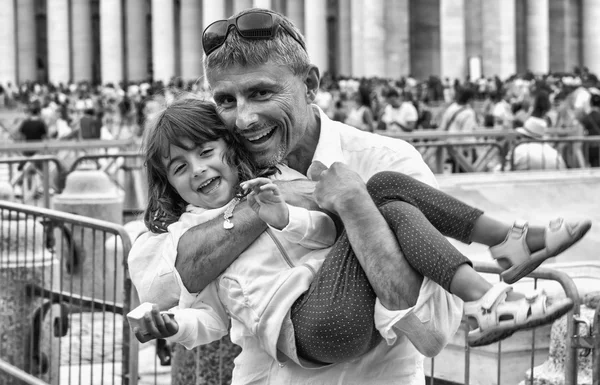 Tyttövauva hymyilee isän sylissä. Kaupunkielämän ja perheen käsite — kuvapankkivalokuva