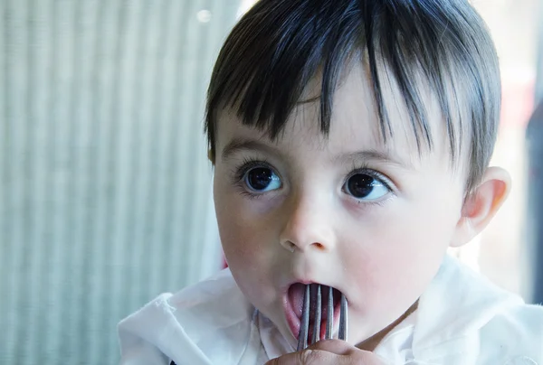 Copil care se preface că mănâncă o furculiță . — Fotografie, imagine de stoc