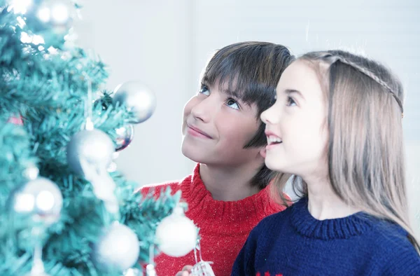 Garçon et fille hypnotisés par l'arbre de Noël — Photo