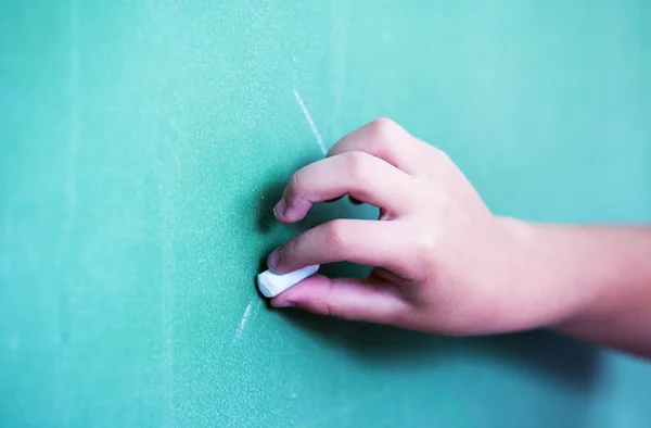 Kid hand holding a white chalk — Stock Photo, Image