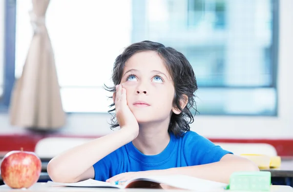 Kind auf Schulbank denkt nach — Stockfoto