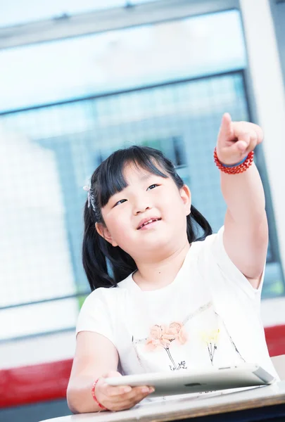 Menina asiática na escola apontando com o dedo — Fotografia de Stock