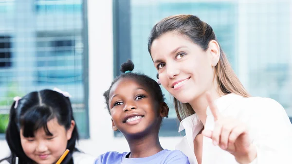 Feliz concepto de escuela multi raza. Profesor sonriendo con los estudiantes — Foto de Stock