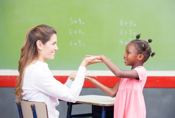 Happy teacher and afroamerican elementary student congratulating — Stock Photo, Image