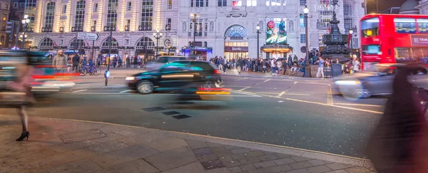 Motion blurred traffic and people walking — Stock Photo, Image