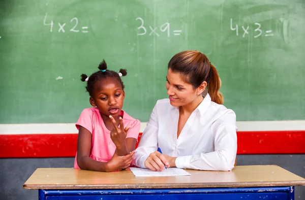 Happy kvinnlig lärare och afro amerikansk skolflicka diskuterar mat — Stockfoto