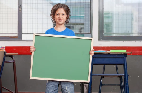 Okul çocuğu ayakta tutan boş yazı tahtası — Stok fotoğraf