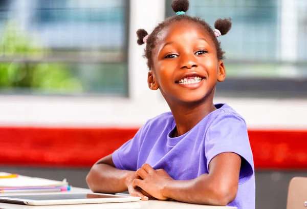 Αφρο αμερικανικό κορίτσι στο δημοτικό σχολείο ευτυχισμένη στο γραφείο της — Φωτογραφία Αρχείου