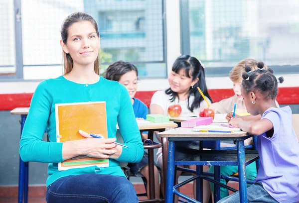 Onun çok ırklı schoolchildr ile mutlu güzel kadın öğretmen — Stok fotoğraf