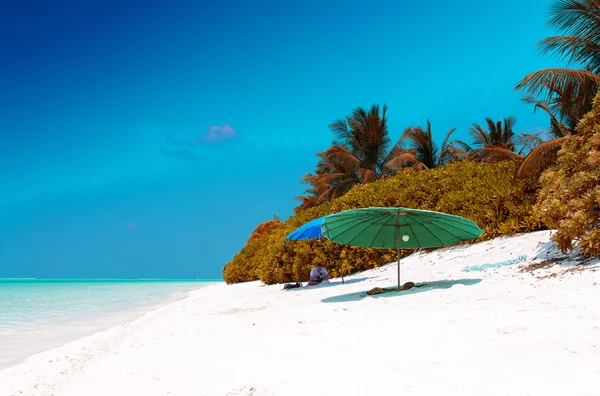 Plażowy parasol na białym piaskiem — Zdjęcie stockowe