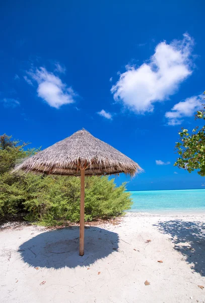 Тропический пляж с соломенным зонтиком — стоковое фото