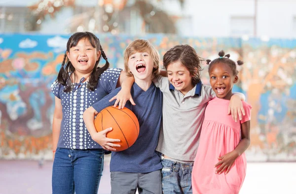 I bambini delle scuole elementari felici di giocare a basket a scuola — Foto Stock