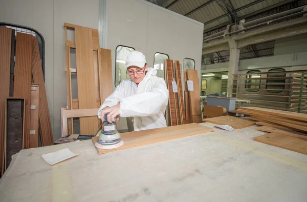 Shed with a skilled carpenter working with wood board — Stock Photo, Image