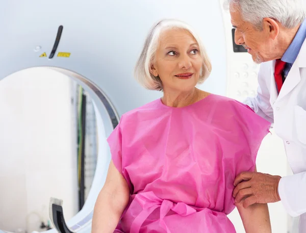 Зрелый врач успокаивает пациентку насчет сканирования — стоковое фото