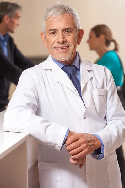 Впевнений усміхнений зрілий чоловік лікар в залі очікування лікарні — стокове фото
