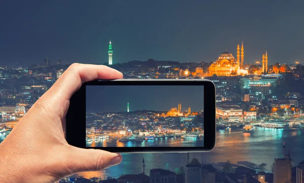Main masculine avec smartphone prenant une photo d'Istanbul la nuit . — Photo
