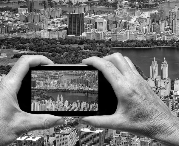 Man en vrouw hand vastleggen luchtfoto skyline van New York met smartp — Stockfoto