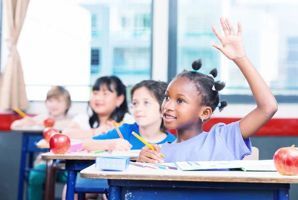 Afro-amerikai lány emeli kezét egy multi-faji osztályteremben — Stock Fotó