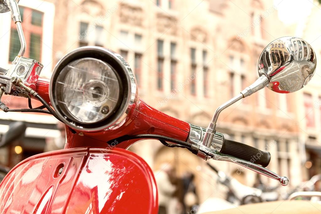 Old fashioned red motorbike parked in city center