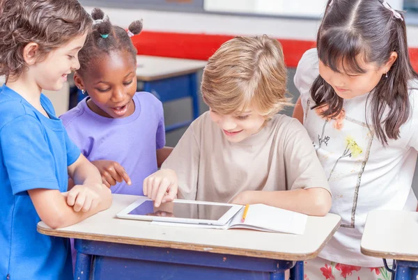 Schoolchildren playing with tablet — Stock Photo, Image