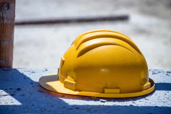 Helm kuning terisolasi di lokasi konstruksi — Stok Foto