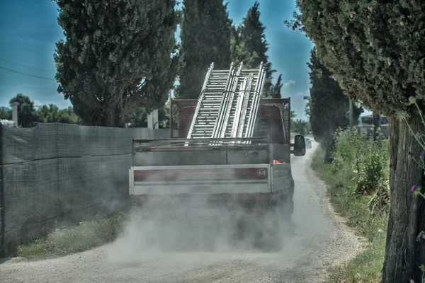 Camión transportando materiales en una carretera polvorienta — Foto de Stock