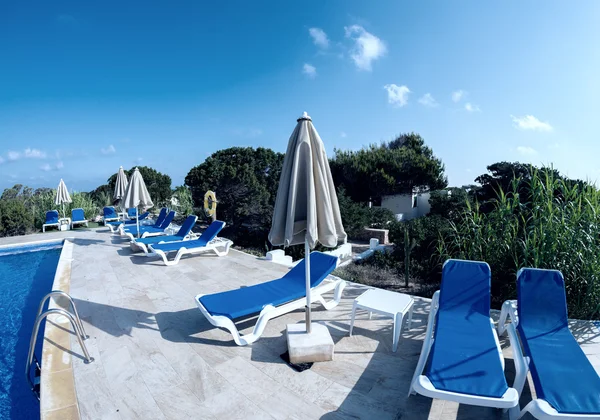 Empty sunbeds at pool — Stock Photo, Image