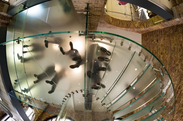 Debajo de la vista de la gente pies caminando sobre una escalera circular —  Fotos de Stock