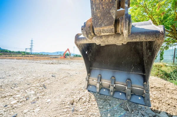 Stora grävmaskin på nya byggplatsen, i bakgrunden bl — Stockfoto