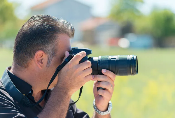 Fotógrafo con dslr tomando fotos al aire libre en verano —  Fotos de Stock