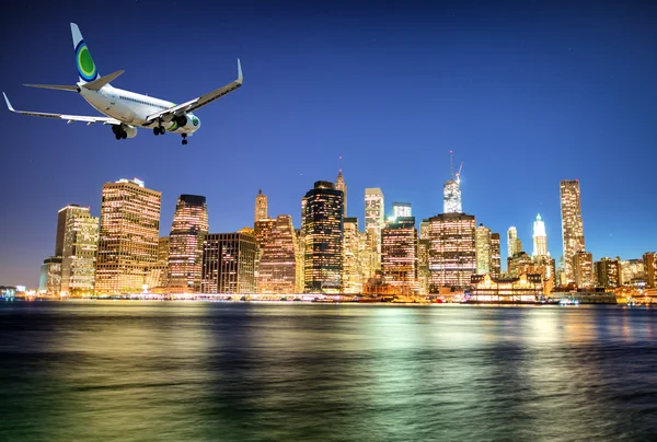 Airplane landing in New York at night. — Stock Photo, Image