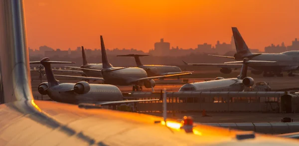 airplanes at airport at sunset