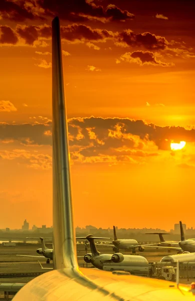 Самолеты в аэропорту на закате — стоковое фото