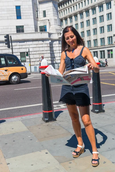 Woman reading newspaper in a London — Stock Photo, Image