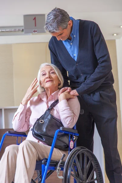 Femme en fauteuil roulant avec assistant — Photo