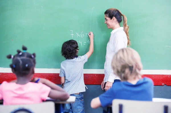 Kid skriva matte på svarta tavlan — Stockfoto