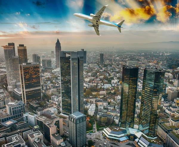 Vliegtuig overvliegen moderne stad — Stockfoto