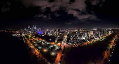 Perth merkez iş bölgesinin yüksek gökdelenleri ve parlayan ışıklarıyla insansız hava aracı görüntüsü..