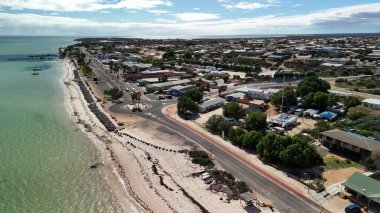 Güneşli bir günde kıyı şeridi ve turkuaz sularıyla Batı Avustralya 'daki Denham kasabasının hava manzarası..