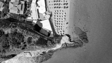 Calabria 'da turkuaz deniz ve güneş şemsiyeli Tropea plajının hava manzarası.