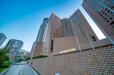 Tokyo, Japonya - 26 Nisan 2025: Günbatımında Shinjuku silueti yüksek modern binalar ve sıcak akşam ışığı.