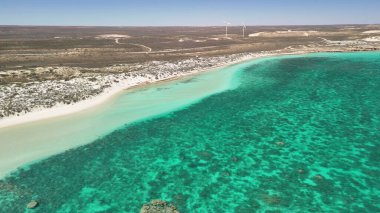Coral Bay kıyı şeridinin insansız hava görüntüsü temiz mavi suları ve WA 'daki kumlu sahili gösteriyor..