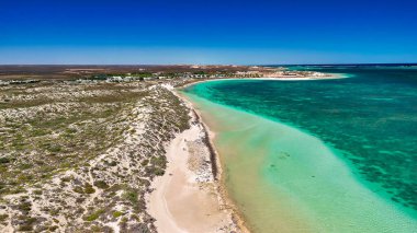 Coral Bay kıyı şeridinin insansız hava görüntüsü temiz mavi suları ve WA 'daki kumlu sahili gösteriyor..