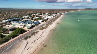 Güneşli bir günde kıyı şeridi ve turkuaz sularıyla Batı Avustralya 'daki Denham kasabasının hava manzarası..